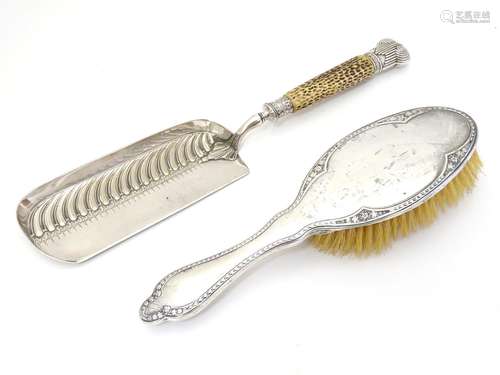 A silver backed brush hallmarked Chester 1914 together with a silver plate crumb scoop with antler