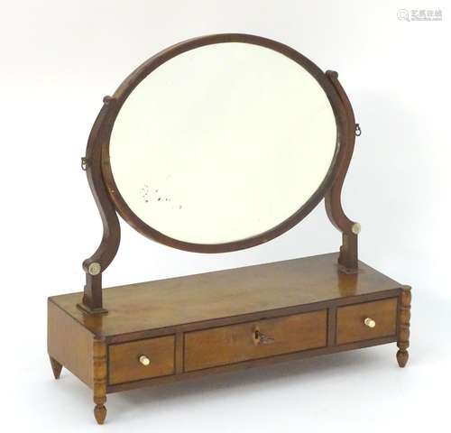 An early 19thC mahogany dressing table mirror, with an oval frame above three short drawers and