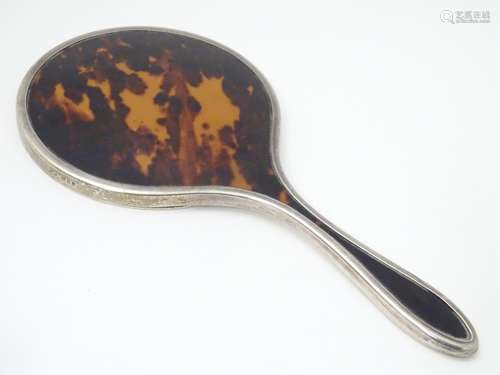 A silver and tortoiseshell hand mirror, hallmarked London 1924, maker Mappin & Webb Ltd. Approx.