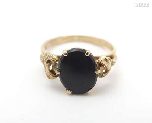 A 9ct gold ring set with black onyx cabochon. Ring size approx H. Please Note - we do not make