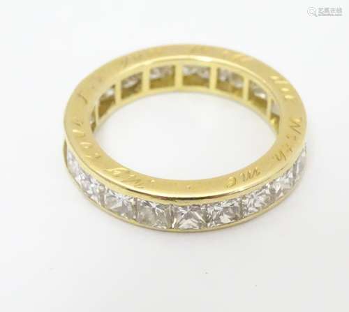 An 18ct gold eternity ring set with 22 Princess cut diamonds. Each diamond approx 3.5mm wide. Ring