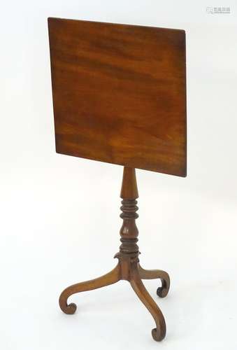 A late 18thC / early 19thC mahogany tilt top table with a turned pedestal base and three scrolled