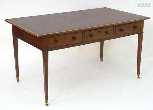 A late 18thC / early 19thC mahogany writing table with an inset top above three short drawers and