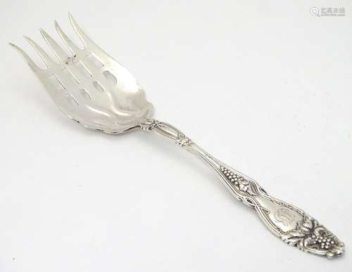 An American Sterling silver serving fork with fruiting vine decoration to handle. 9