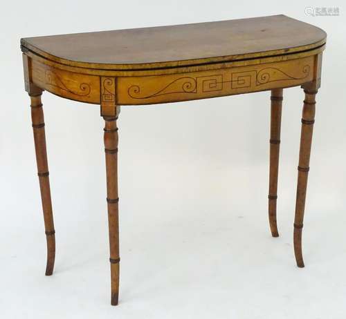 A 19thC satinwood card table with a D-shaped top and a twin gate leg mechanism supporting a