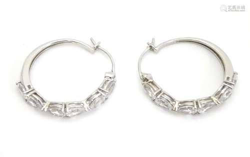 A pair of white metal hoop earrings set with six pear shaped white stones. Stamped 925. Approx. 1