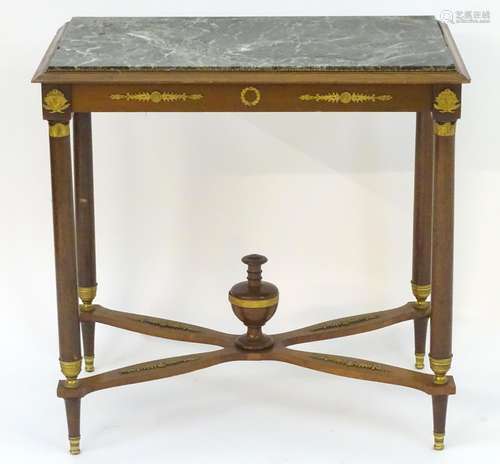 A French Empire mahogany table with a rectangular marble top above applied gilt decorations, the