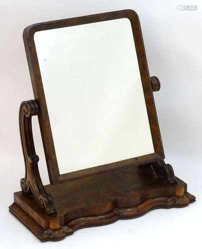 A late 19thC mahogany dressing mirror with a rectangular moulded frame and carved supports above a