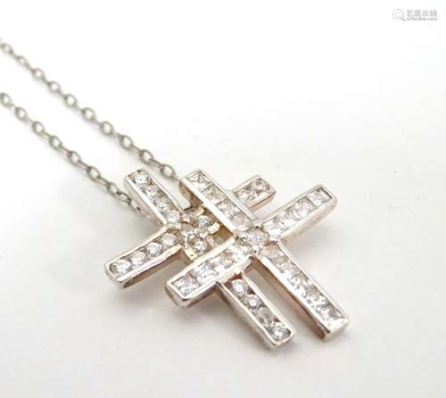 A silver and white metal pendant on chain, the pendant formed as a white stone set double cross.