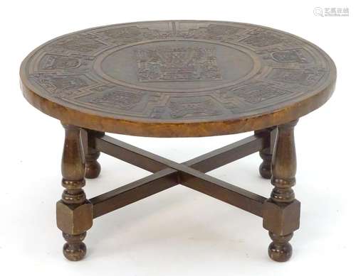 An Andean mohena wood and leather circular coffee table, having four legs with cross struts and a