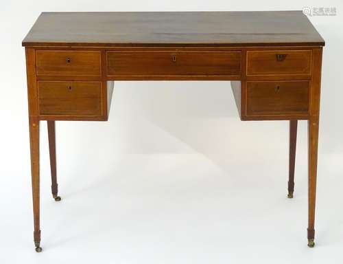 A Georgian mahogany writing desk with a rectangular top above a single long drawer flanked by two