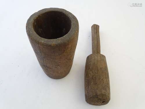 Kitchenalia: a 19thC carved walnut pestle and mortar, of large proportions and roughly finished, the