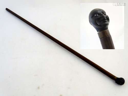 A walking stick / cane with a carved ebonised pommel formed as a male negro human head with an