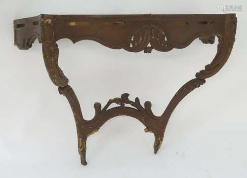 An 18thC carved console table with a carved and shaped apron above carved legs and supporting