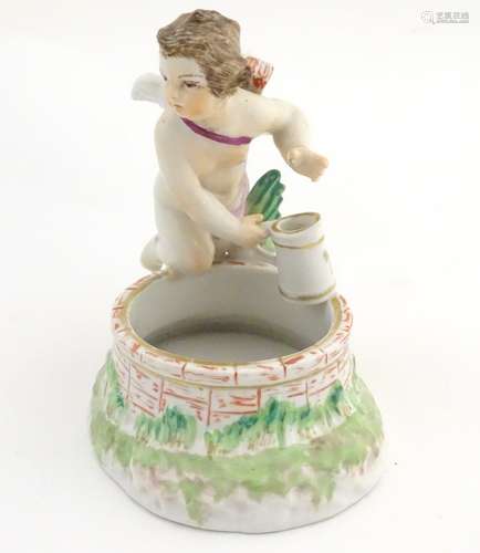 A 19thC Berlin salt modelled as a cherub holding a tankard above a brick well, the interior