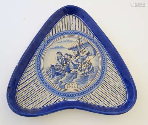 An 18thC Dutch blue and white dish of triangular form. Decorated with a central roundel depicting