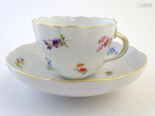 A 19thC Meissen cup and saucer decorated with flowers and gilt highlights. Meissen marks under cup