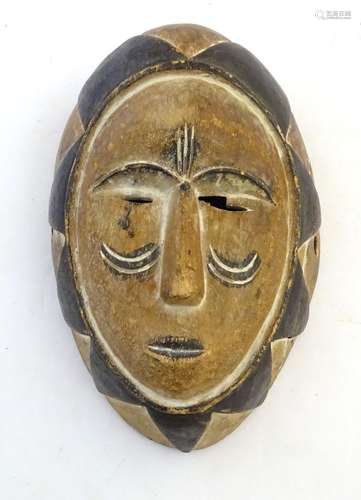 Ethnographic / Native / Tribal: A carved and painted figural mask with geometric detailing.