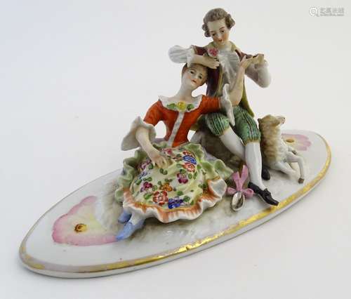 A Continental porcelain oval lid decorated with seated lovers and a lamb, with gilt highlights.