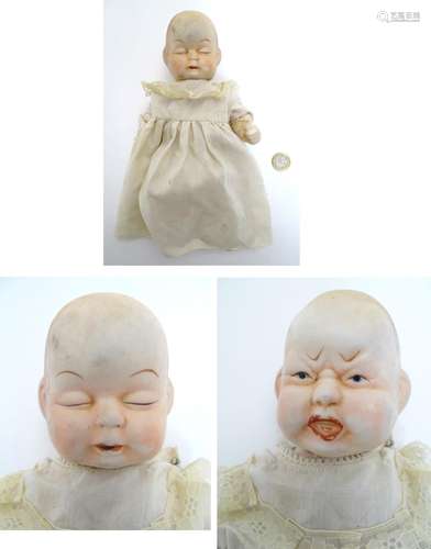 Toy: A bisque doll with two faces: one sleeping and one crying, with articulated arms and legs,