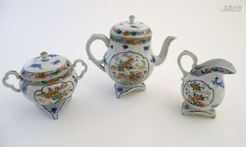 A Japanese teapot, twin handled sugar bowl and milk jug decorated with hand painted insects and