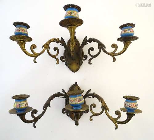 Lighting: a pair of early 20thC triple wall sconces, of gilt brass construction with ornamental