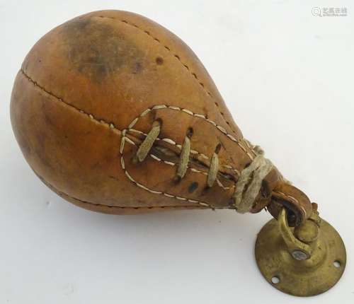 A 20thC leather boxing gym punch ball, with brass loop and ceiling mount. Approx. 7 1/2