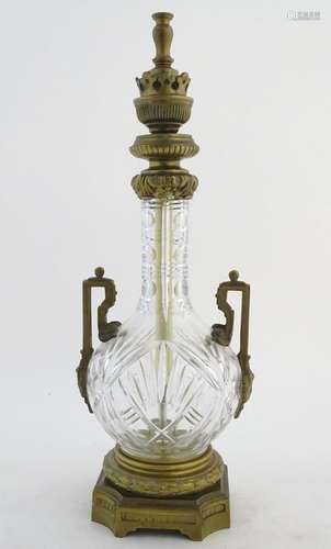 An early-20thC glass table lamp, decorated with prism, star, roundel and vesica cuts, fitted with