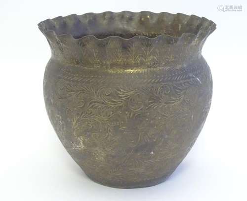 An Indian brass planter with a lobed rim, decorated with stylised figures among scrolling foliage.