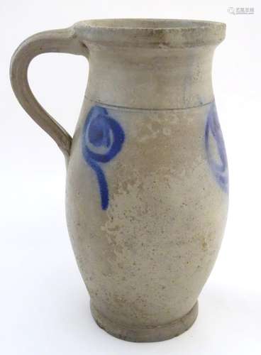 A studio pottery vase with a single handle and stylised blue flower decoration. Incised 21 under