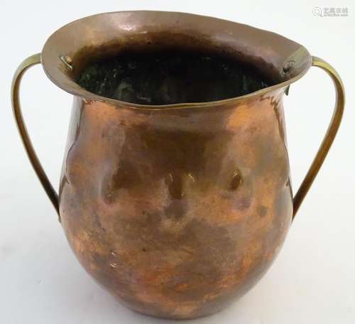 An Arts and Crafts twin handled copper pot with a flared rim and hammered detail. Approx. 6