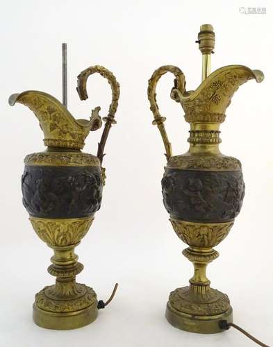 A pair of early-20thC table lamps formed as wine ewers, decorated in ormolu with putti and