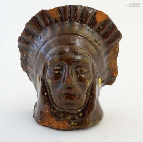 A 19thC treacle and slip glazed terracotta window stop formed as the bust of Native American