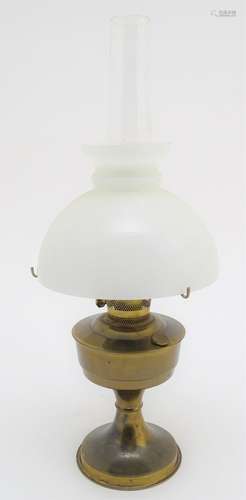 A 20thC oil lamp with a milk glass shade. Approx. 24 1/4