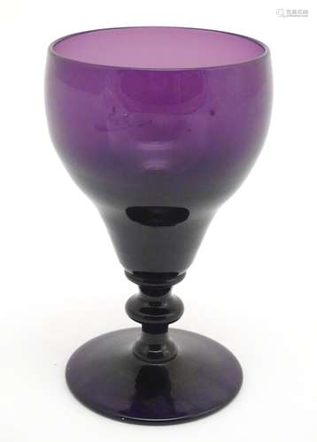 A 19thC amethyst glass wine glass, with knopped stem. 6