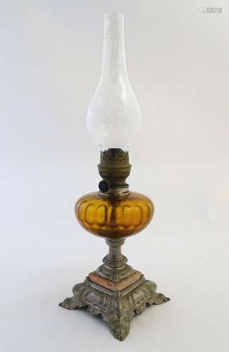 An early-20thC French oil table lamp, with 'Matador' burner, the amber glass reservoir supported