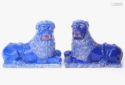 A pair of 19thC faience Luneville lions with a cobalt blue glaze. Depicting recumbent lions on