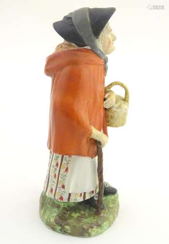 An 18th / 19thC Staffordshire figure modelled as an old lady in a bonnet carrying basket. Approx. 7