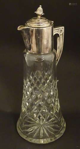 An early 20thC cut glass claret jug with silver plated mounts, the finial formed as a pineapple. 13