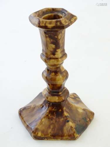 An English 18th / 19thC hexagonal candlestick with a mottled treacle glaze. Approx. 6 1/4