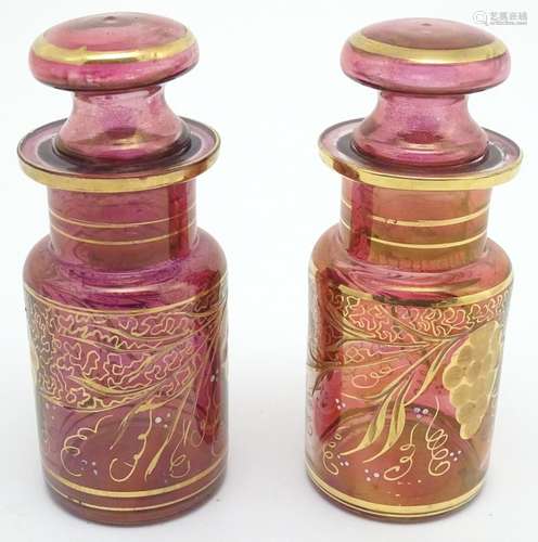 A pair of 19thC cranberry glass jars, each decorated with hand painted vines and bands. 7 1/2