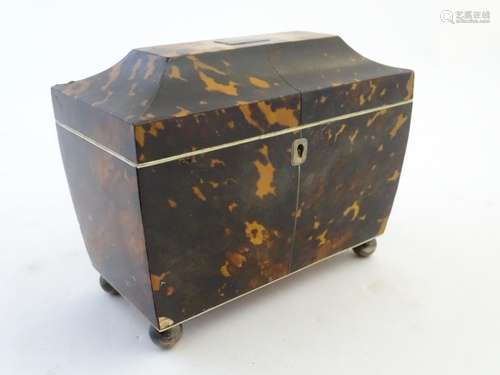 A 19thC tortoiseshell tea caddy of sarcophagus form tih a hinged lid and two lidded sections within.