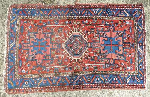 Carpet / rug: A red and blue ground rug decorated with geometric and cruciform patterns and stylised