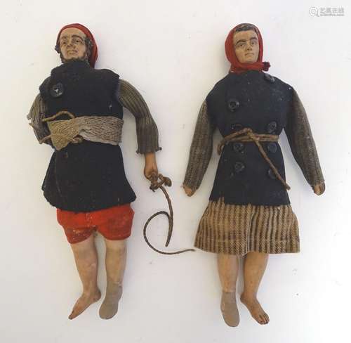 A pair of naive early 20thC primitive dolls formed as a man and a woman with ceramic heads, arms and