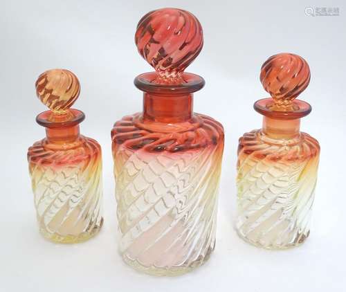 A c1920s graduated trio of Baccarat crystal / glass 'rose tiente' dressing table bottles, each