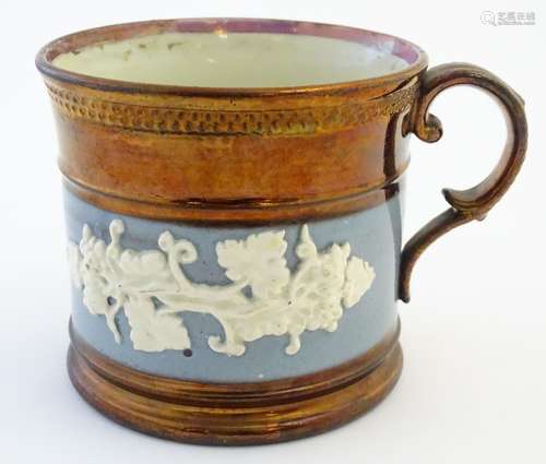 A 19thC copper lustre mug with banded vine decoration in relief and pink lustre rim. Approx. 3 1/