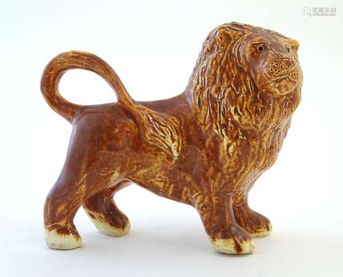 A Paula Humphries Polperro Cornwall studio pottery model of a lion. Marked under paw with