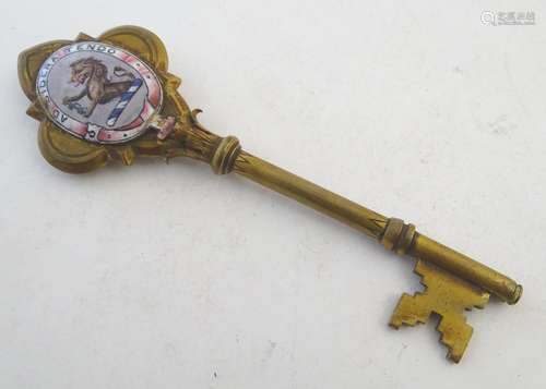 A 19thC brass presentation key with enamel detail depicting a lion holding a key with the Latin