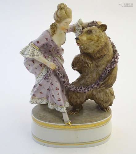 A Copenhagen style figural group with a woman dancing with a bear with a garland of flowers.