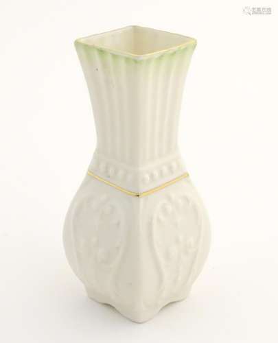 A small Belleek bud vase of squared form with fluted neck and relief decoration. Approx. 4